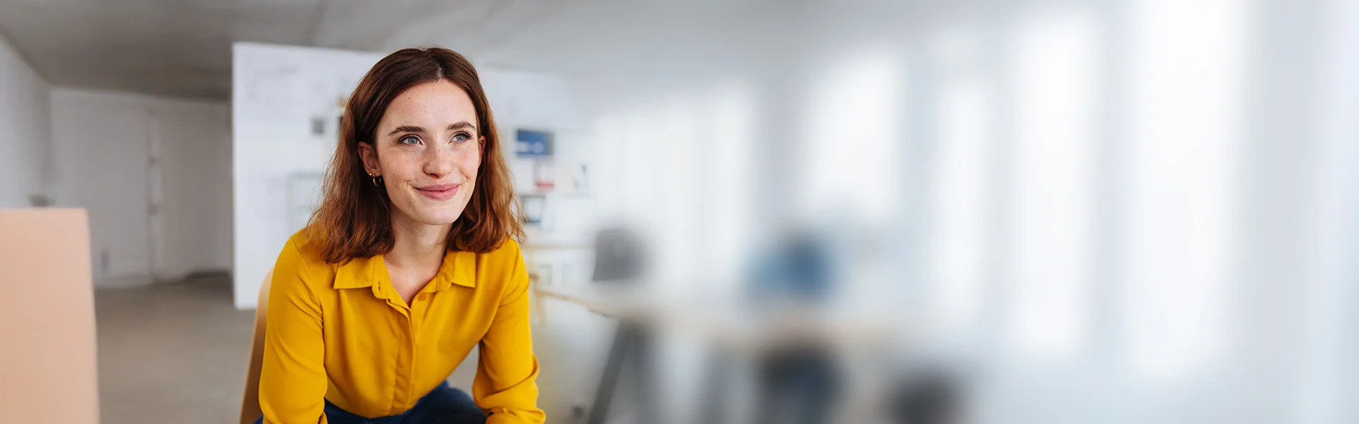 eine Frau in einem gelben Hemd und schwarze Hose steht in einem Büro