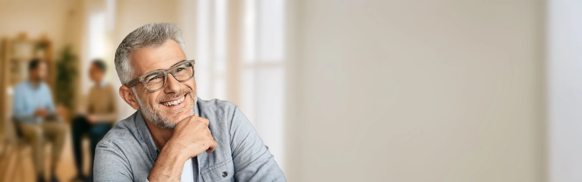 ein Mann mit Brille lächelnd, während er die Kamera anschaut