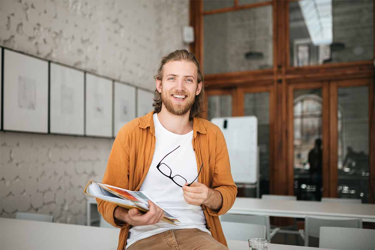 ein Mann sitzt an einem Tisch mit einem Buch und einem Becher