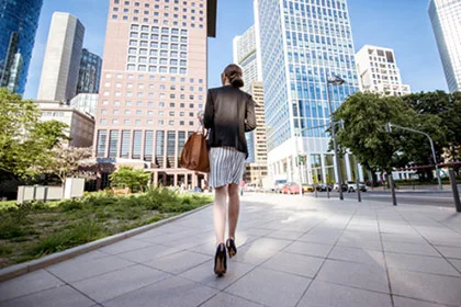 eine Frau, die in einer Stadt einen Bürgersteig hinuntergeht