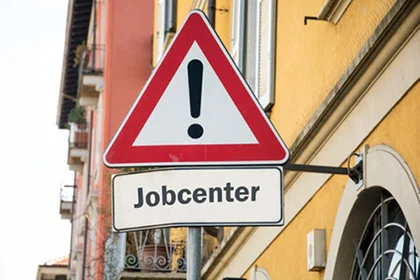 ein Straßenschild auf einer Stange mit Aufschrift Jobcenter