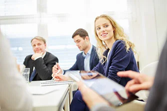 eine Gruppe von Menschen, die um einen Tisch sitzen